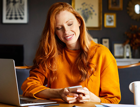 Woman with cell phone and laptop