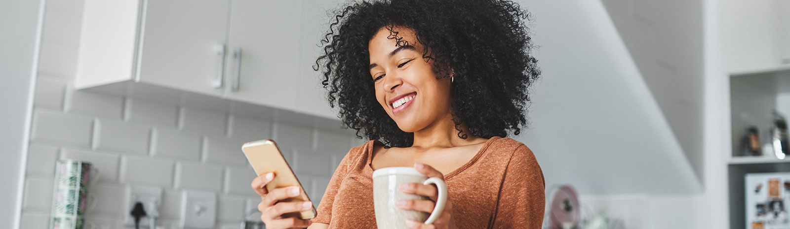 Woman on a cell phone holding a coffee